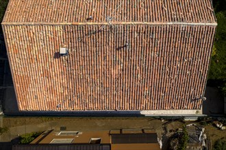 Top down view of a roof with terracotta tiles casting shadows in soft light