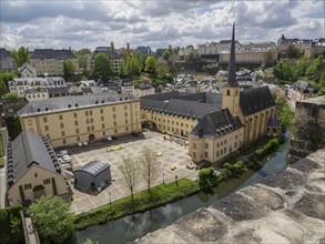 Panorama of a city with historical buildings, a church and a river under a cloudy sky in spring,