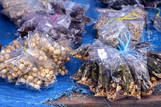 Assorted plastic bags of different dried spices and herbs like Aleurites moluccanus or candlenut,