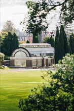 Domain conservatory in the park in Auckland, meadow in the foreground and skyline in the background