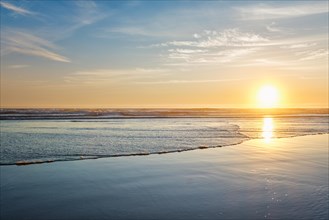 Atlantic ocean sunset with surging waves at Fonte da Telha beach, Costa da Caparica, Portugal,