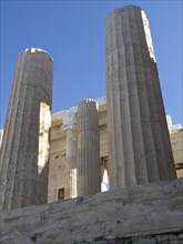 Close-up of ancient columns with shadows against blue sky, historical columns and ruins at an