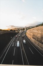 Motorway with blurred vehicles in daylight with urban background. Madeira, Portugal, Europe