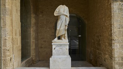 Statue without head and arms on a column in a niche, courtyard, torso of a Roman statue, Grand