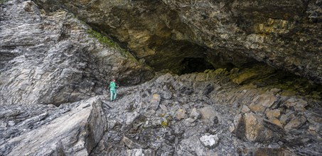 Hiker exploresObstans ice cave in Alta Pusteria, Carnic Alps, East Tyrol, Austria, Europe