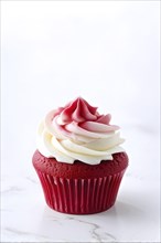 Cupcake with delicate icing swirls with a cherubic ruby red fondant decoration, AI generated