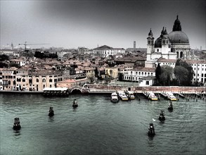 A view of Venice with historic buildings and a church on the waterfront on a cloudy day, church
