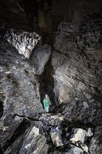 Hiker explores Obstans ice cave in Alta Pusteria, Carnic Alps, East Tyrol, Austria, Europe