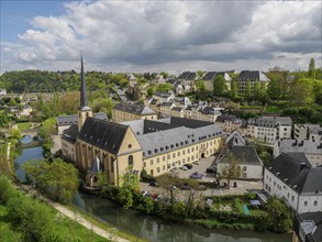 View of a historic town with a large church and river surrounded by older buildings under a cloudy