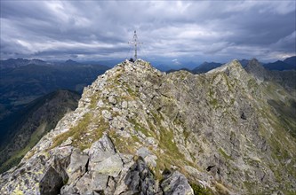 Rocky pointed summit of the Raudenspitze or Monte Fleons with summit cross, mountain panorama on