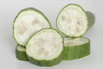 Sponge cucumber or sponge pumpkin (Luffa aegyptiaca, Luffa cylindrica), sliced fruit on a white