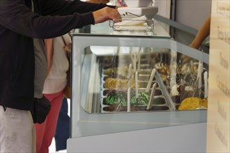Customers buying ice cream in an ice cream parlor on the street