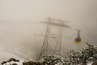 Cable car technicians working in bad weather conditions, Nebelhorn cable car near Oberstdorf,