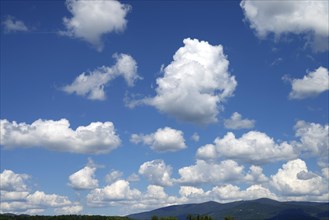 Blue sky with many white clouds over a mountain landscape, Bavarian Forest above Deggendorf,
