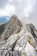 Rocky narrow summit ridge, cloudy mountain peak, summit of the Great Kinigat, Carnic Main Ridge,