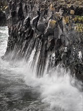 Surf on dramatic basalt cliffs, surrounded by sea spray and powerful natural scenery, Iceland,