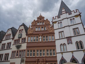 Historic gothic buildings with richly decorated facades under a cloudy sky, historic house fronts
