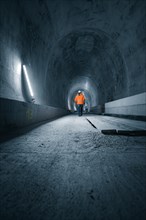 Person in safety clothing exploring a tunnel, tunnel construction Hermann Hessebahn, Ostelsheim,