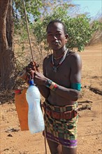 South Ethiopia, Omo region, man from the Karo people with water bottles, plastic bottles filled