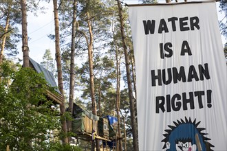 Tree houses and banners Water is a human right! (Water is a human right!) in the occupied section