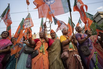 Bharatiya Janata Party (BJP) supporters dancing as they arrives to to see a roadshow of Union Home