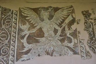 Damaged ancient mosaic with a winged mythological figure of Triton, god of the sea, and decorative