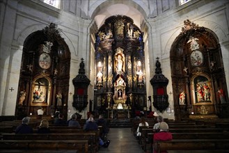 Iglesia San Nicolas de Bari, Baroque church interior with elaborately designed altar and images of
