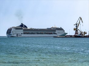 Huge cruise ship from shipping company MSC arrives in Iraklion harbour emitting plume of exhaust
