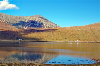 The rounded rugged mountains of the Cullins and two houses on an inlet, Isle of Skye, Scotland,