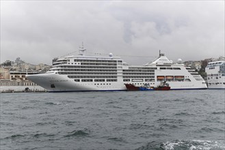 White cruise ship SIVER SPIRIT, with several decks on a rough sea on a grey day, Istanbul Modern,