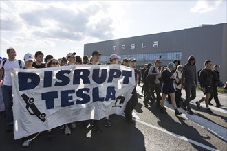 Participants with banner Disrupt Tesla in front of the Tesla Gigafactory at the demonstration Water