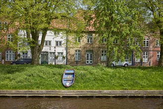 Old wooden boat and historic houses on Mittelburggraben in Friedrichstadt, North Friesland