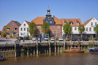 Skipper's house and harbour basin with boats in Toenning harbour, Nordfriesland district,