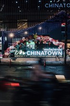 Illuminated entrance sign to Chinatown in Bagkok Thailand at night. In the foreground typical