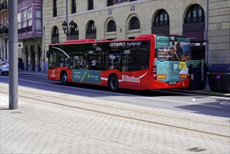 On the road in Bilbao, Province of Bizkaia, Basque Country, Spain, Europe, Red hybrid bus with