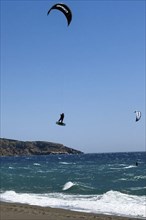 Kitesurfer Kitesurfer takes off in strong wind and waves rough sea moving sea flies with inflated