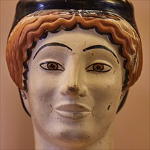 Attic vase in the shape of a woman's head, Midas, A painted ceramic face sculpture with vivid