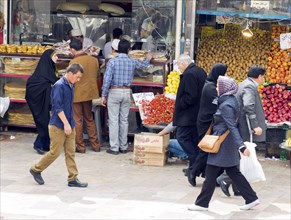 Iranians walk past stalls selling fruit and vegetables at a bazaar in Tehran, 29/03/2015, Tehran,