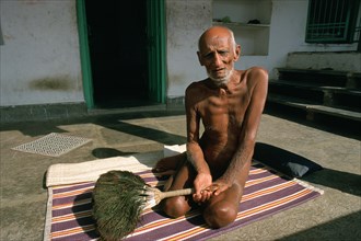 Jain monk sitting in front of the cell where he is staying at that time, portrait of a naked monk