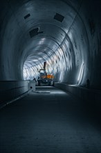 Tunnel with an excavator, little light creates a quiet atmosphere, tunnel construction Hermann