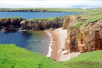 Lonely beaches, red cliffs and green meadows, Hillswick, Eshaness, Shetland Islands, Scotland,