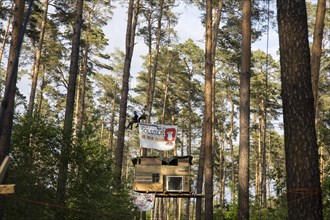 Two people swing above a tree house in the occupied section of the Tesla Stop forest. The
