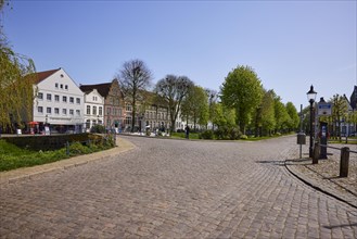 Cobbled streets with the Great Bridge, trees and historic houses in Friedrichstadt, Nordfriesland