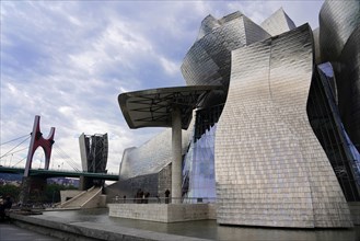 Guggenheim Museum Bilbao, Spain, Europe, The picture shows modern metallic buildings next to a red