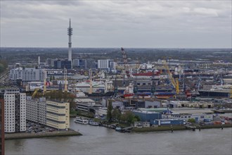 Industrial area of a city with harbour facilities, cranes and modern buildings on a cloudy day,