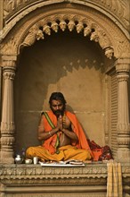 Hindu man worshipping the sun god Surya, Varanasi, India, Asia