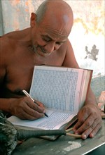 Jain monk writing his thoughts on his personal book, naked monk from the digambar sect, Rajasthan,