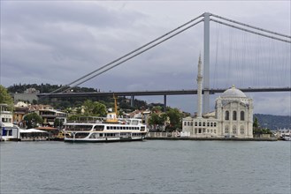 View of a bridge and mosque on the coastline under a cloudy sky, Istanbul, Istanbul Province,