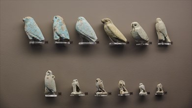 Miniatures, Falcons, Various small bird statues in blue and beige, lined up against a neutral