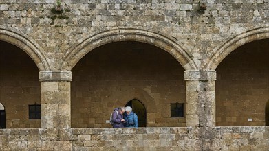 Two people in a stone archway having a dialogue, historical atmosphere, outdoor area,